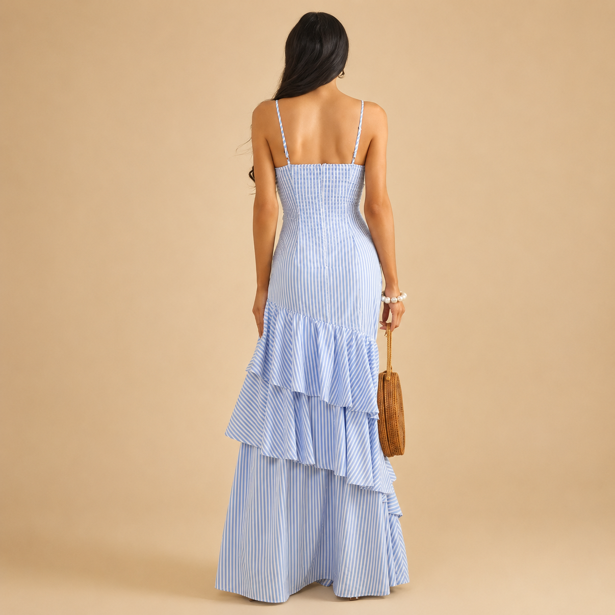 Blue and white striped maxi dress features a ruffled tiered skirt, a tied bust cut-out, and spaghetti straps