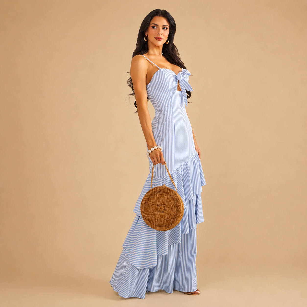 Blue and white striped maxi dress features a ruffled tiered skirt, a tied bust cut-out, and spaghetti straps