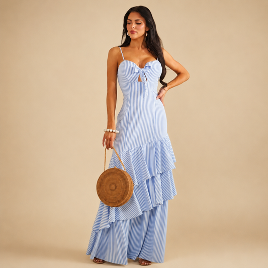 Blue and white striped maxi dress features a ruffled tiered skirt, a tied bust cut-out, and spaghetti straps